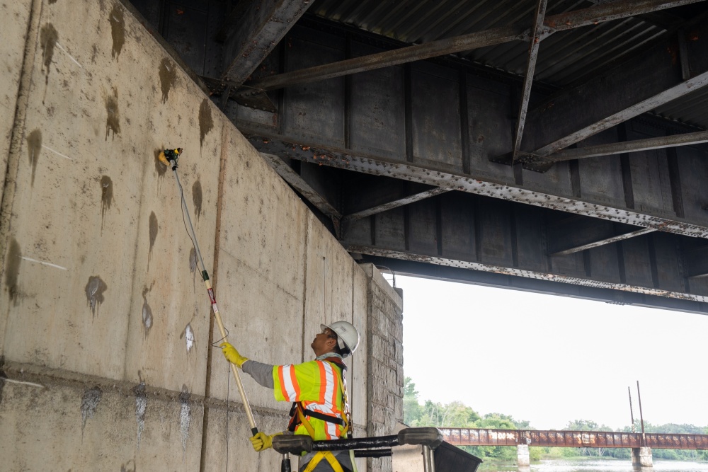 An engineer performs a corrosion potential test on concrete bridge pier